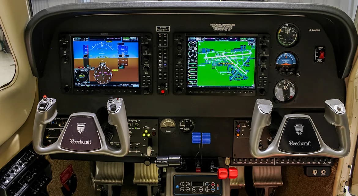The cockpit of a Beechcraft Baron G58, featuring two large Garmin G1000 displays and dual yokes.