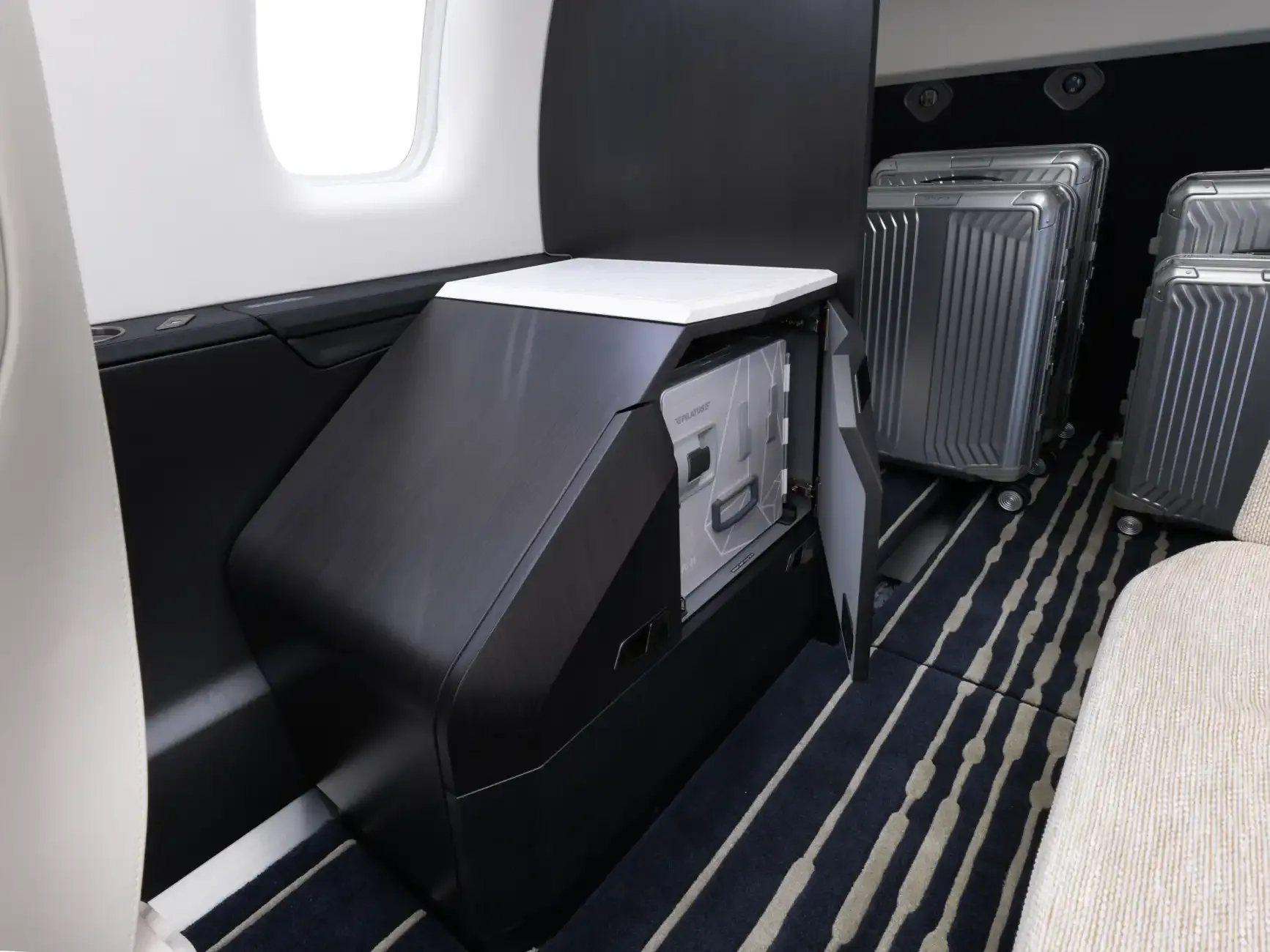 View of the aircraft interior with a storage unit and luggage.
