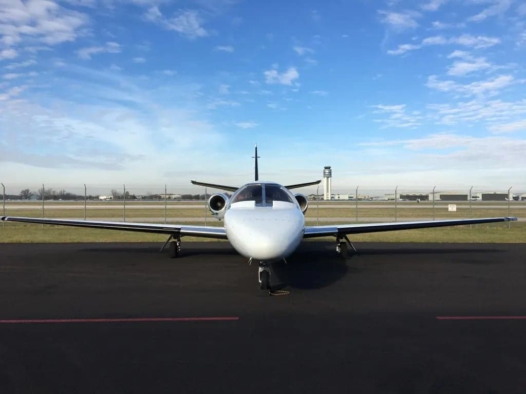 Front view of a white Cessna CitationJet on the tarmac.