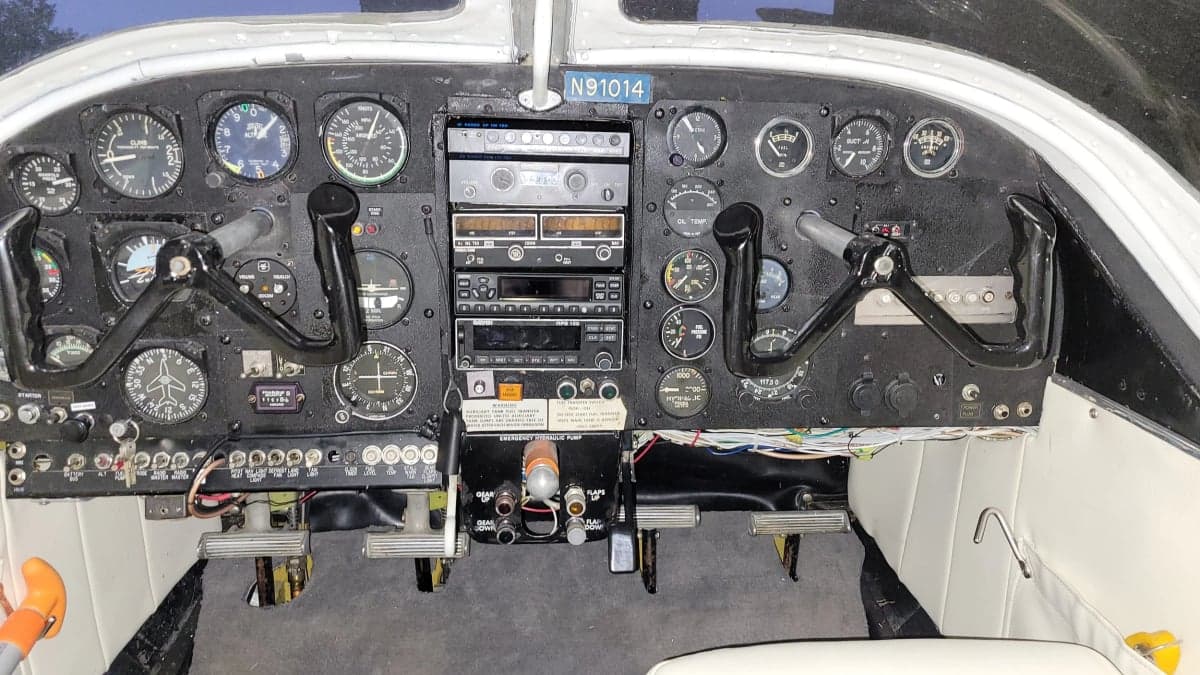 The cockpit of the aircraft features a full instrument panel and white seats.