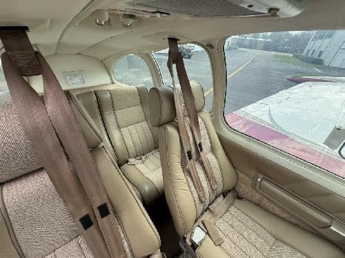 The interior of the aircraft features tan seats and seatbelts.