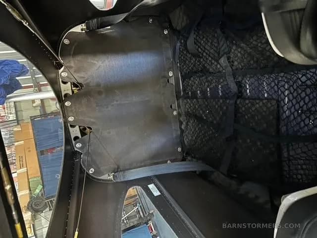 The interior view of the aircraft's rear baggage compartment with black netting.