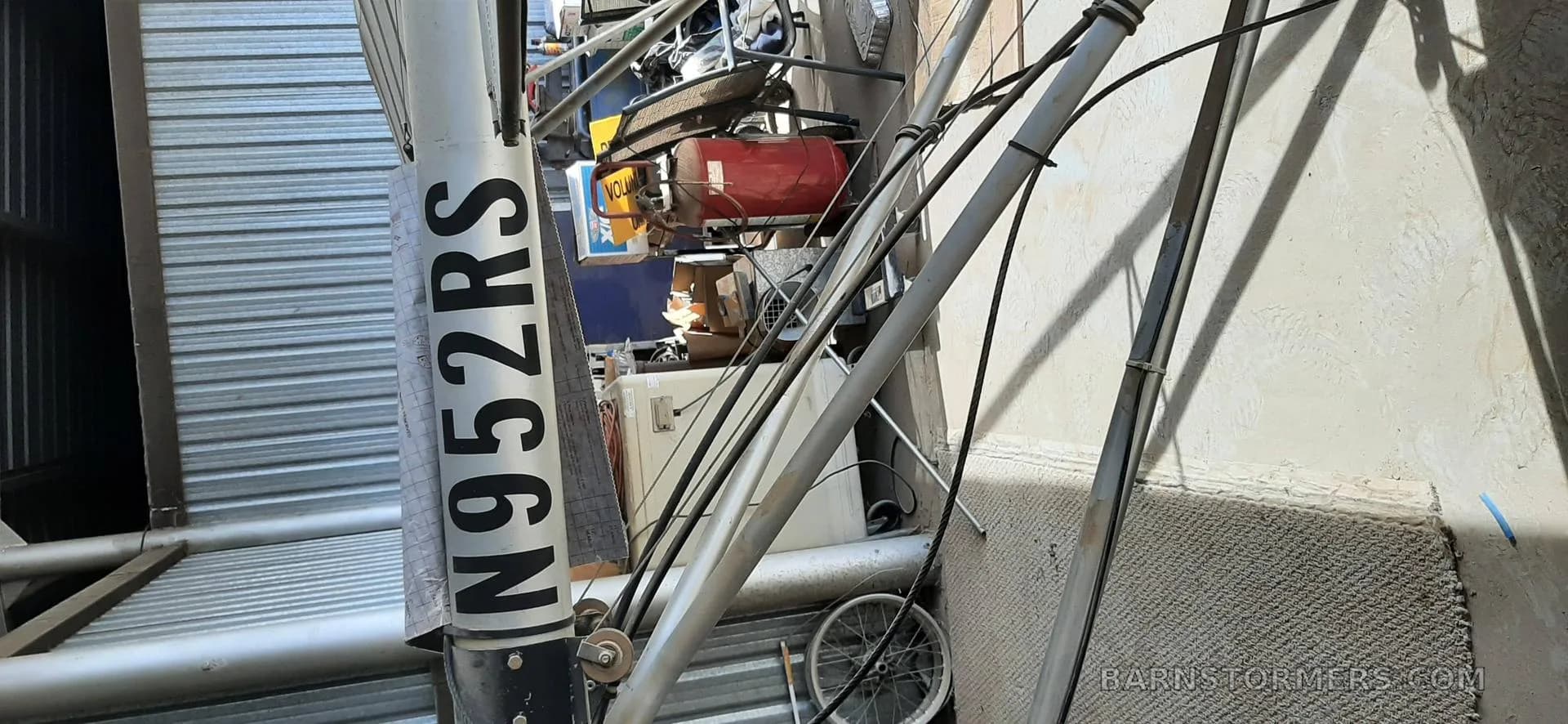 A close-up view of the tail boom of an ultralight aircraft, showing the registration number N952RS.