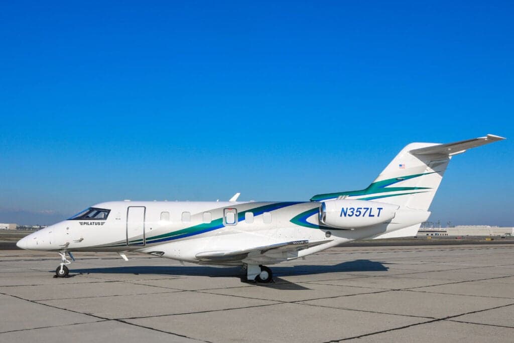 Pilatus PC-24 N357LT parked on the tarmac with a white and teal paint scheme.