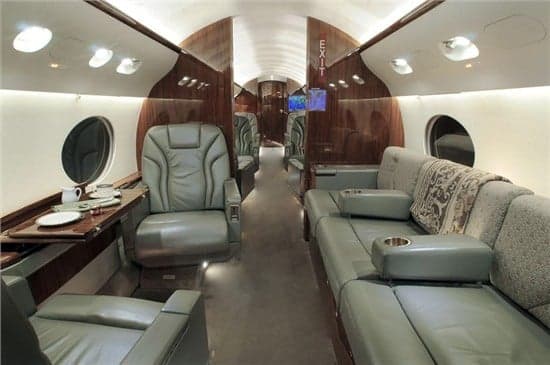 The aircraft's interior features leather seats and wood paneling.