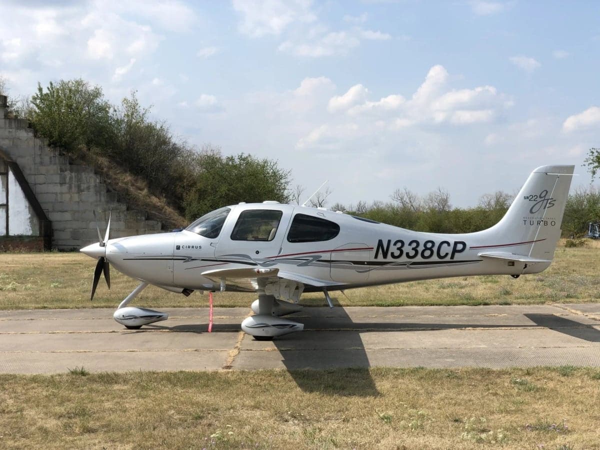 Rear view of the Cirrus SR22T with registration N338CP on the runway.