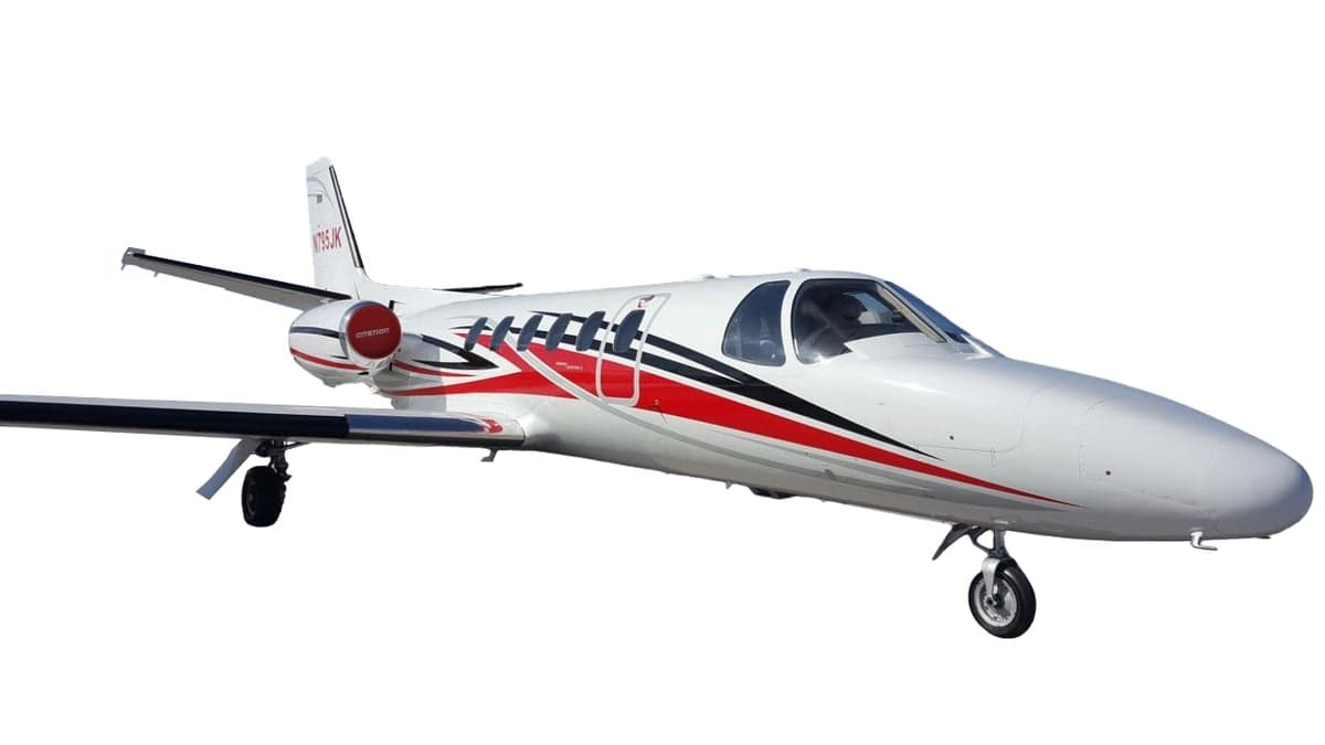 A white Cessna Citation jet with red and black stripes on a white background.