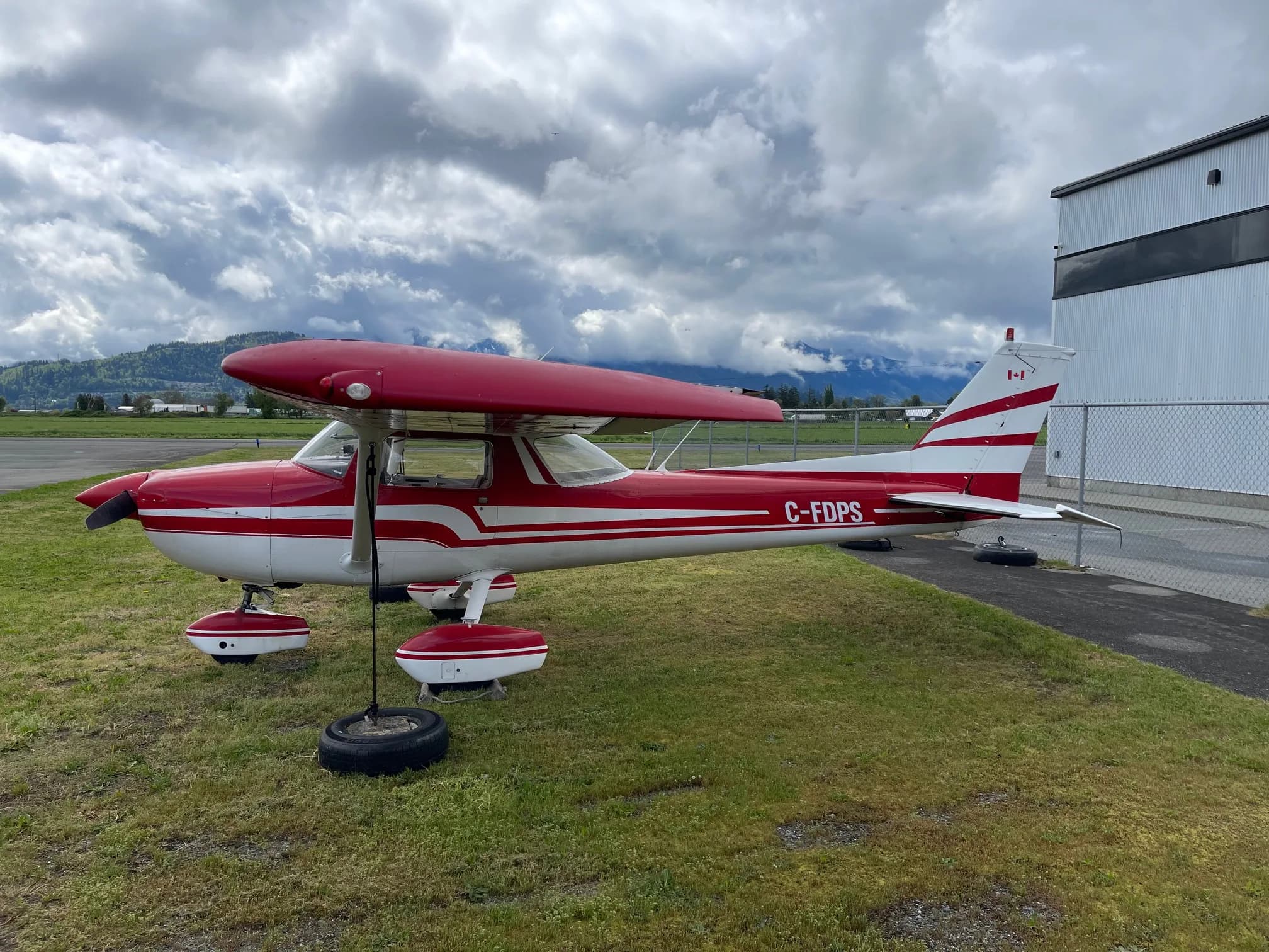 C-FDPS Cessna aircraft with red and white paint scheme, parked on the grass.