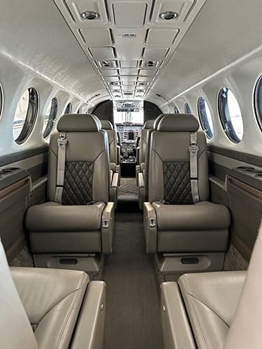 Interior view of the King Air cabin with gray leather seats.