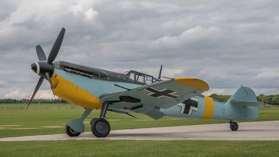 Messerschmitt Bf 109 aircraft in flight against a cloudy sky.