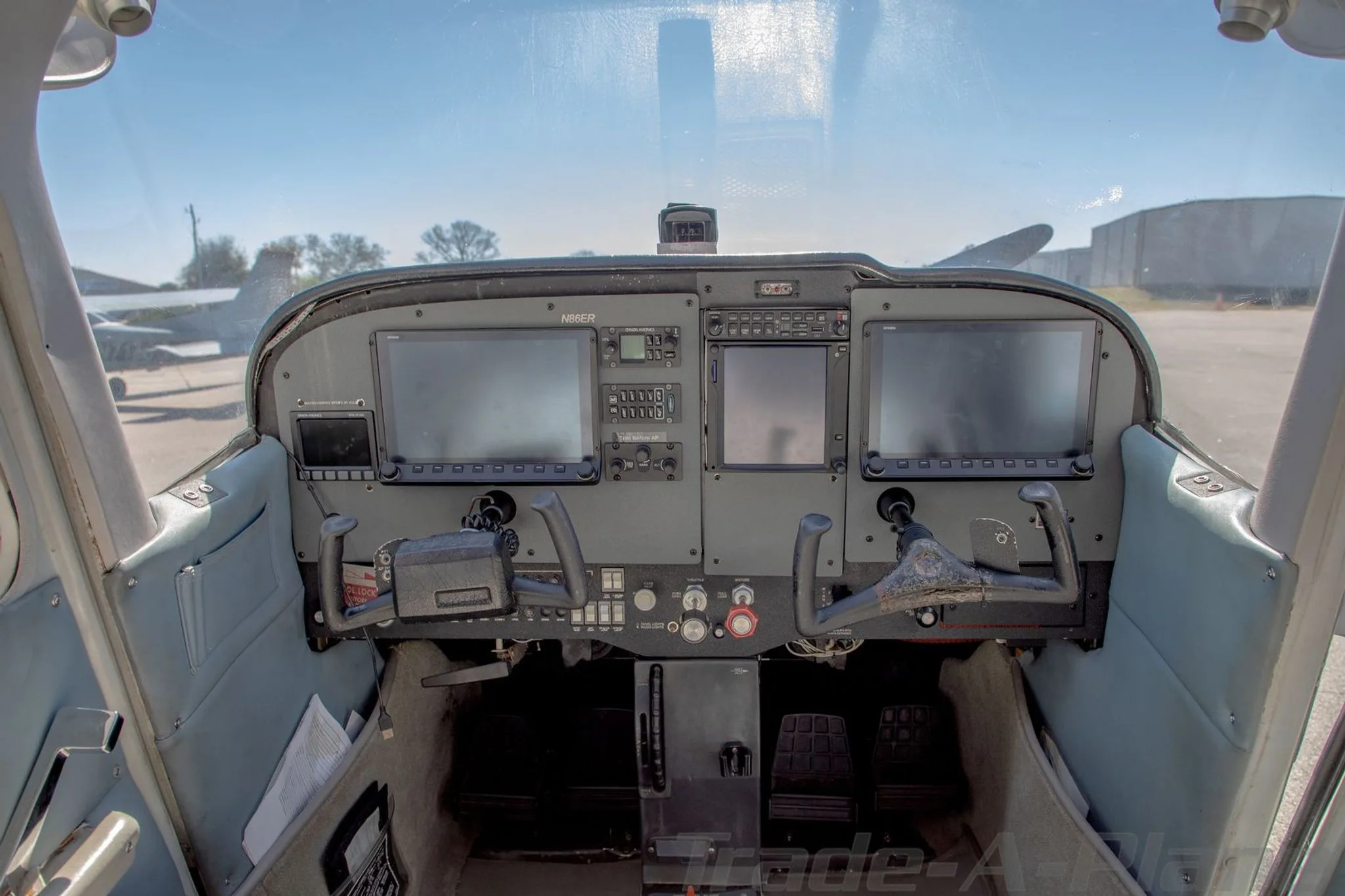 The cockpit of the N86ER aircraft features a modern instrument panel with two large glass displays and traditional yokes.