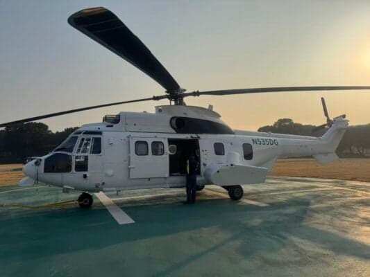 A Eurocopter AS332 Super Puma helicopter with registration N535DG is parked on the tarmac with its door open.