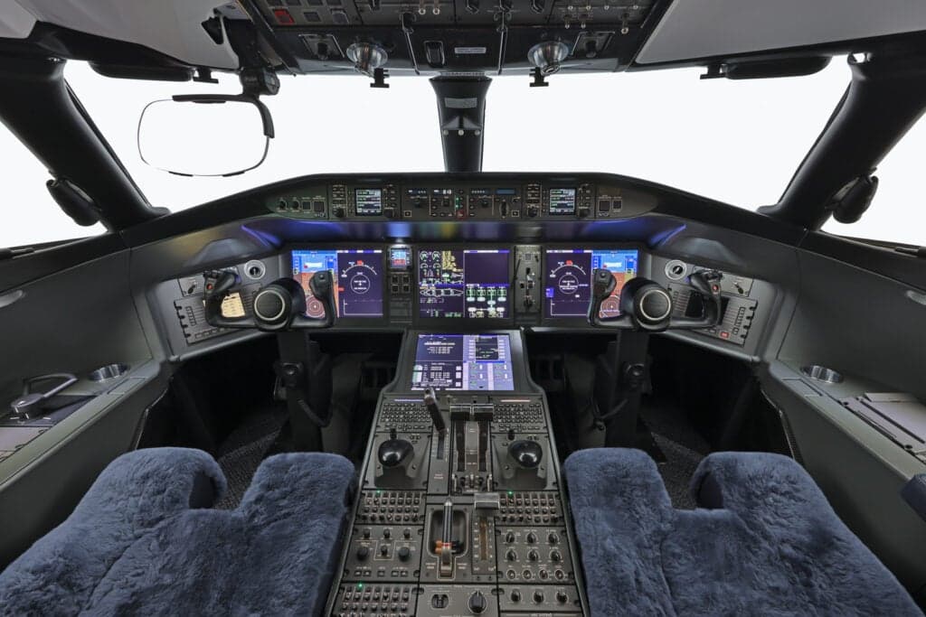View of the aircraft cockpit featuring the instrument panel and pilot seats.