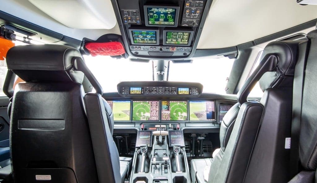 The aircraft's interior features leather seats, a table set for dining, and a Gulfstream-branded monitor.