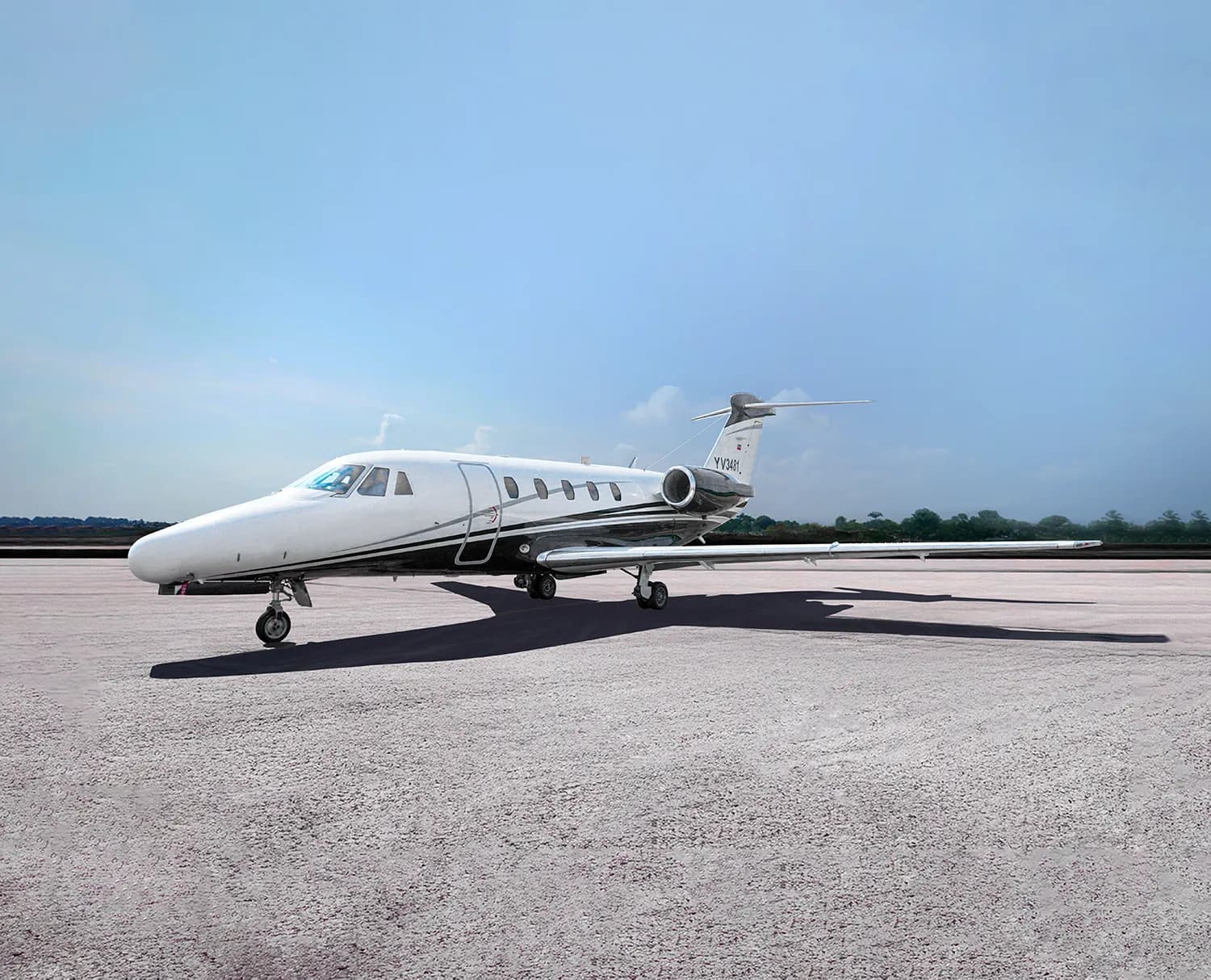 A white and black Cessna Citation business jet, registration YV3481, is parked on an airfield under a clear blue sky, viewed from the front-left.