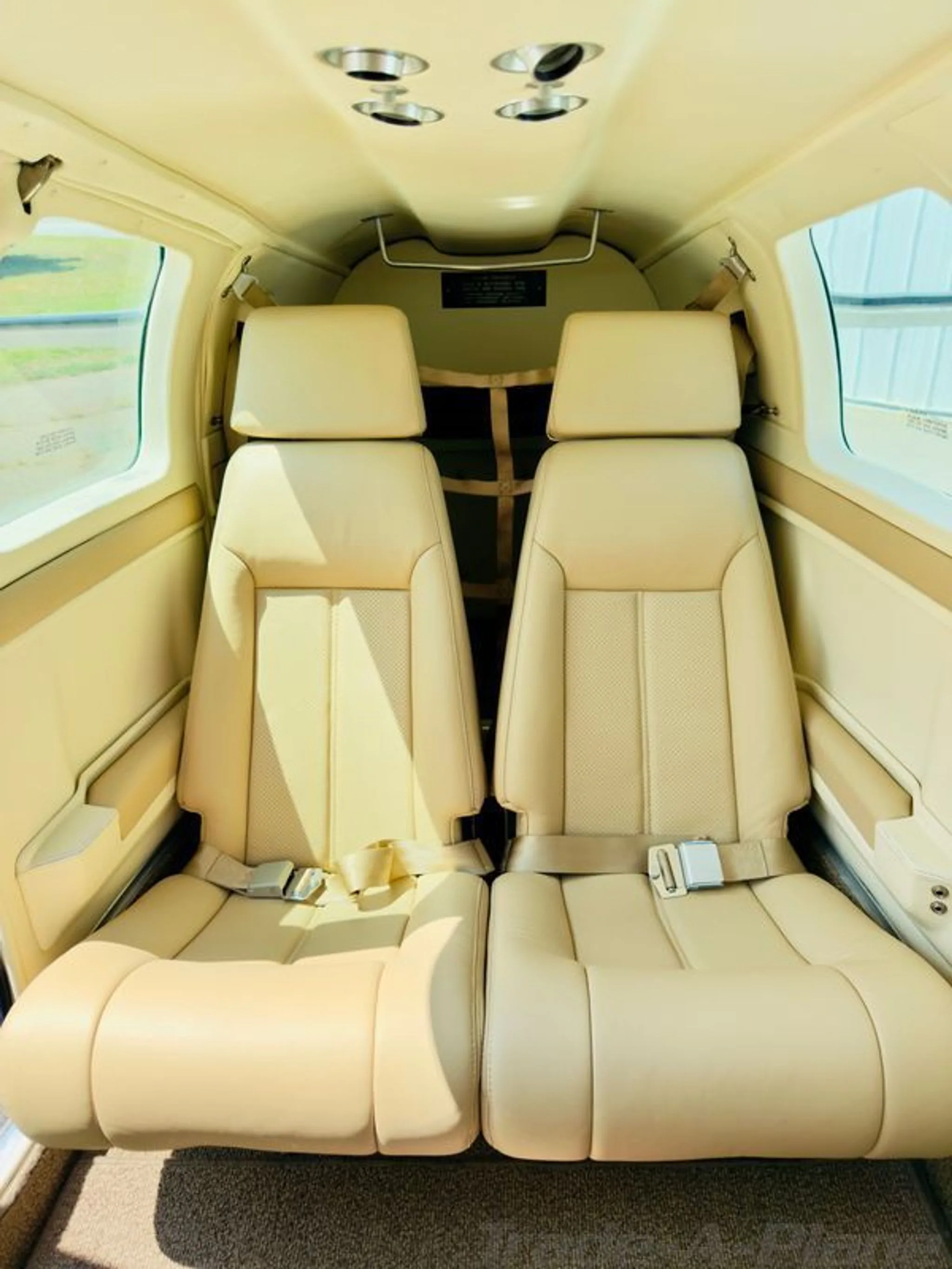 View of the beige leather rear cabin seats of the aircraft.