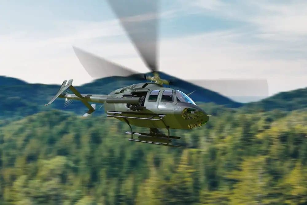A Bell 407 helicopter flying over a forest.