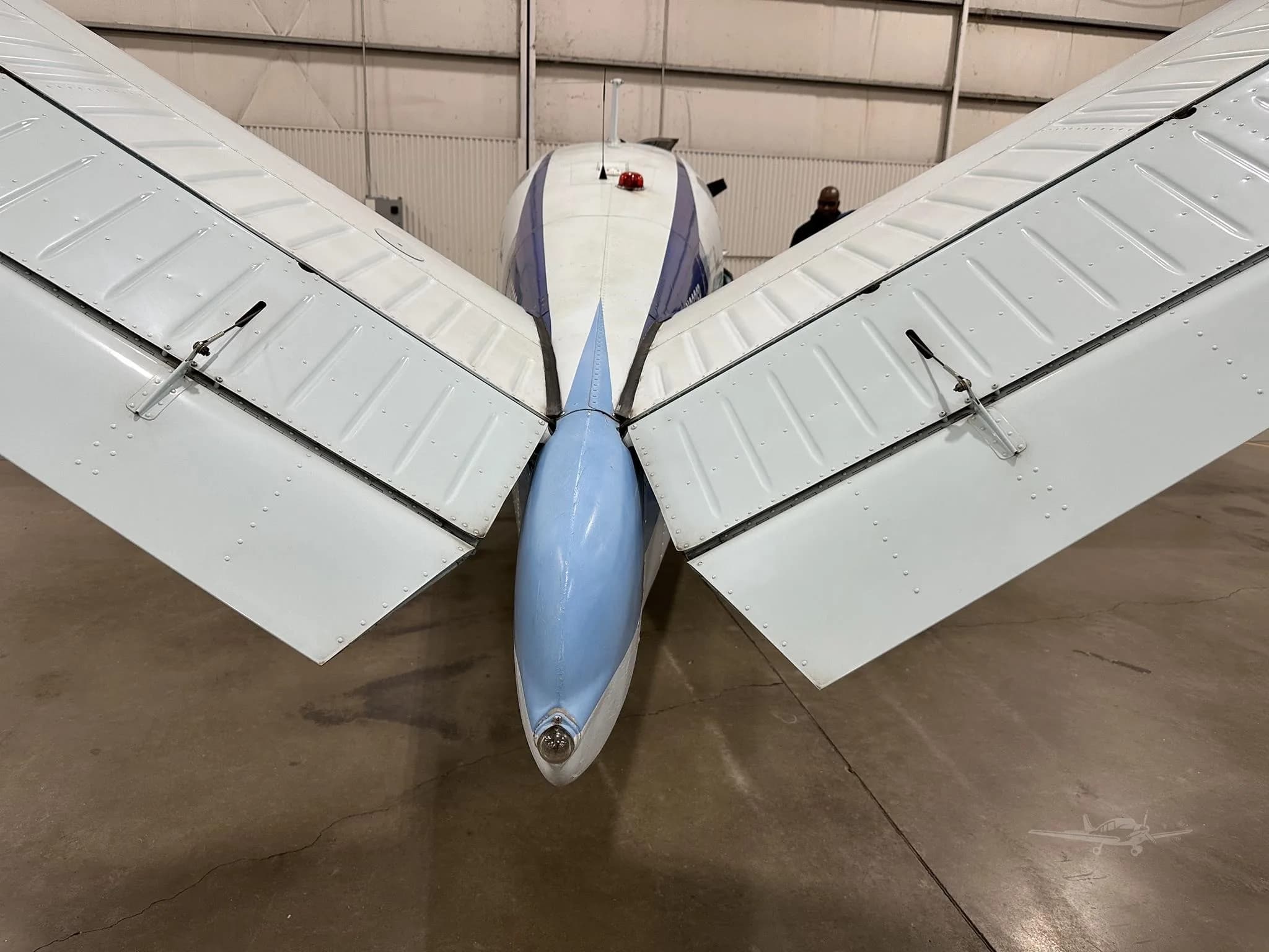 A close-up view of the V-tail and rear fuselage of the white and blue Beechcraft Bonanza N9936R.