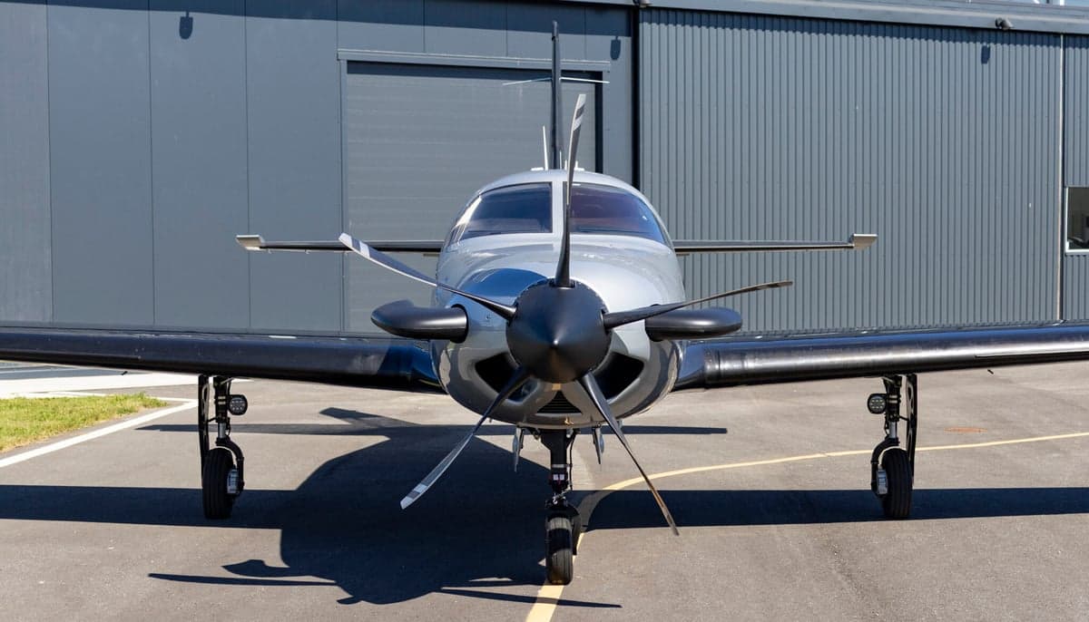 Front view of a gray and black aircraft on the tarmac.