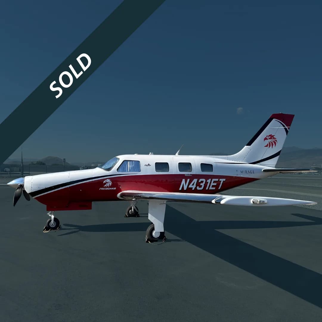 A white and red Piper Mirage aircraft with registration N431ET is parked on an tarmac.