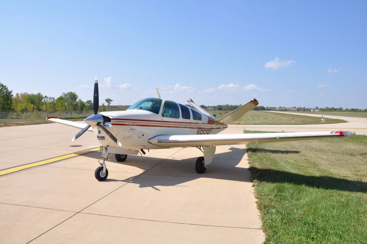 A Beechcraft Bonanza aircraft with tail number N651PC is parked on the tarmac.