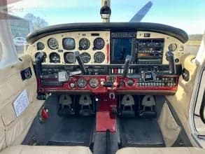 The cockpit of a Piper PA-28 Cherokee, showing the instrument panel and controls.