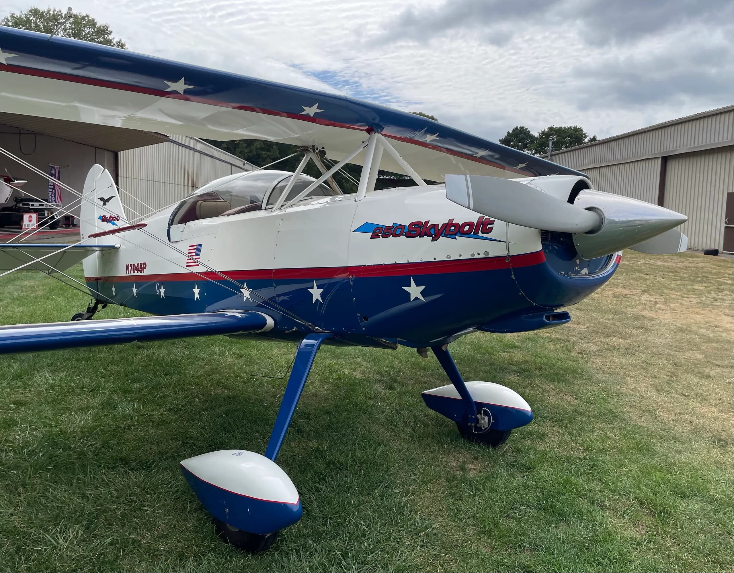 A close-up front-right view of the Acro Sport II Skybolt biplane, showing the propeller and star-themed paint scheme.