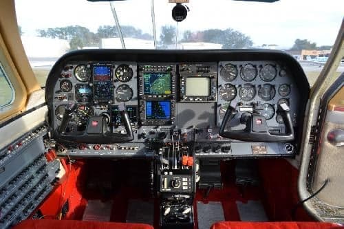 The aircraft's cockpit features a full instrument panel and dual control yokes.