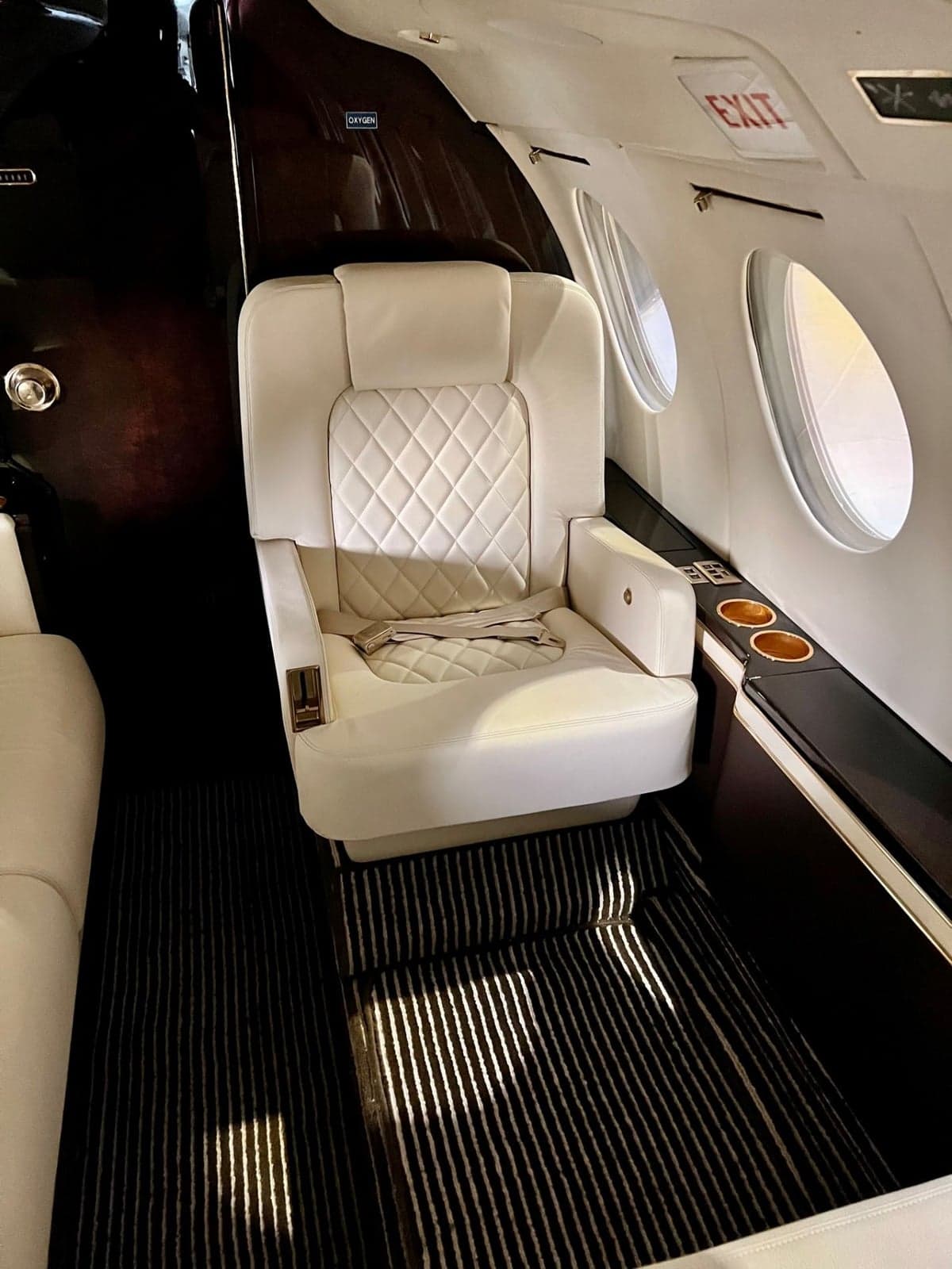 The interior of a Dassault Falcon 900 features white leather seats with diamond stitching.