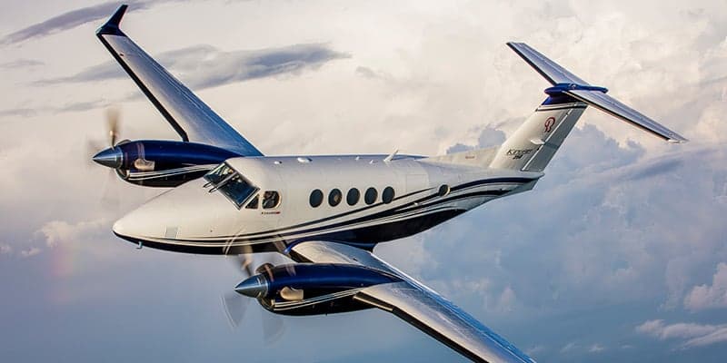 King Air 260 in flight with a white and blue paint scheme.