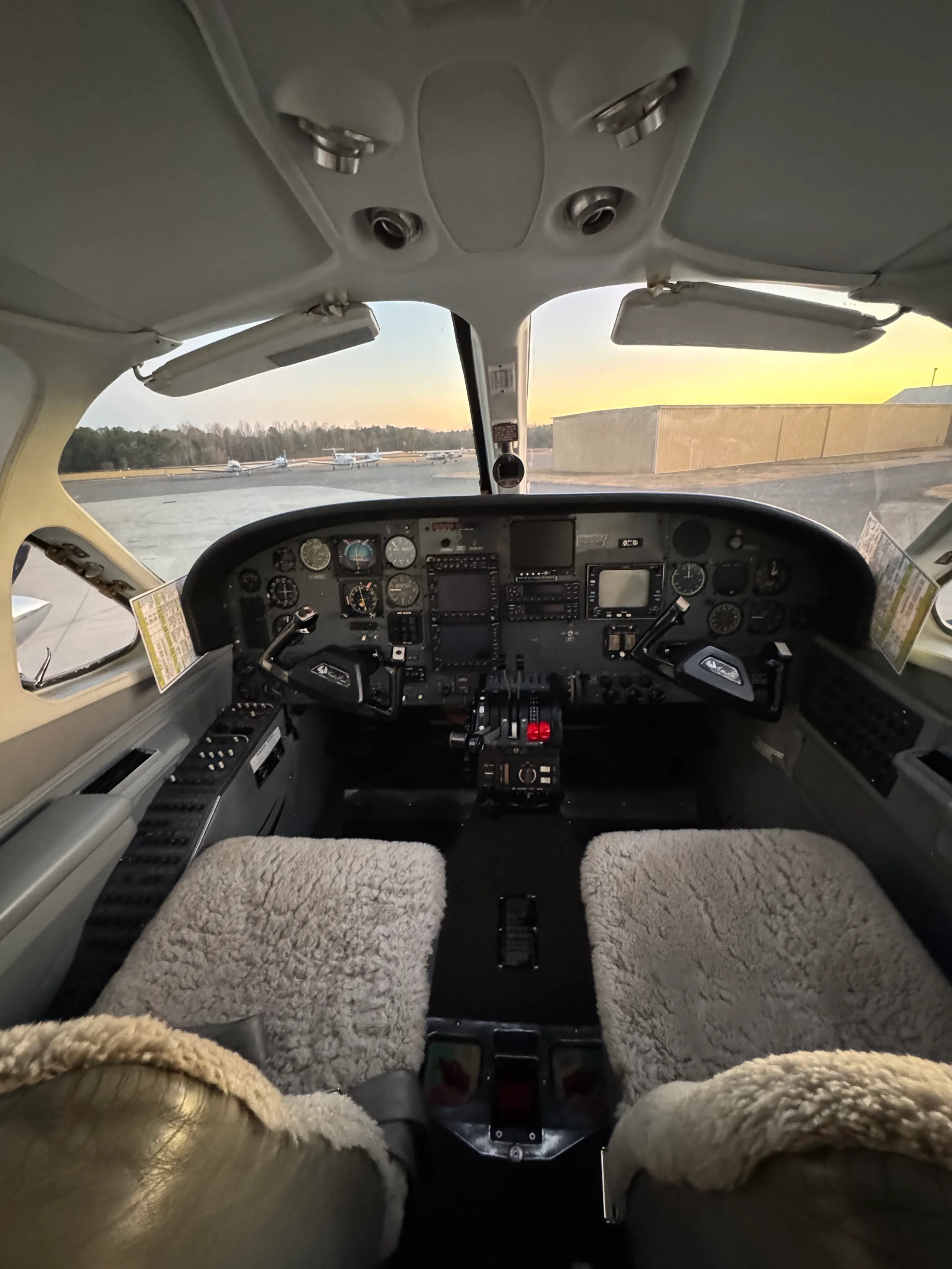 The cockpit of a twin-engine aircraft, N762CA, showing the instrument panel and sheepskin-covered seats.