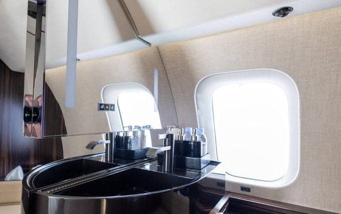 Aircraft interior with a bed and a monitor displaying an aircraft image.