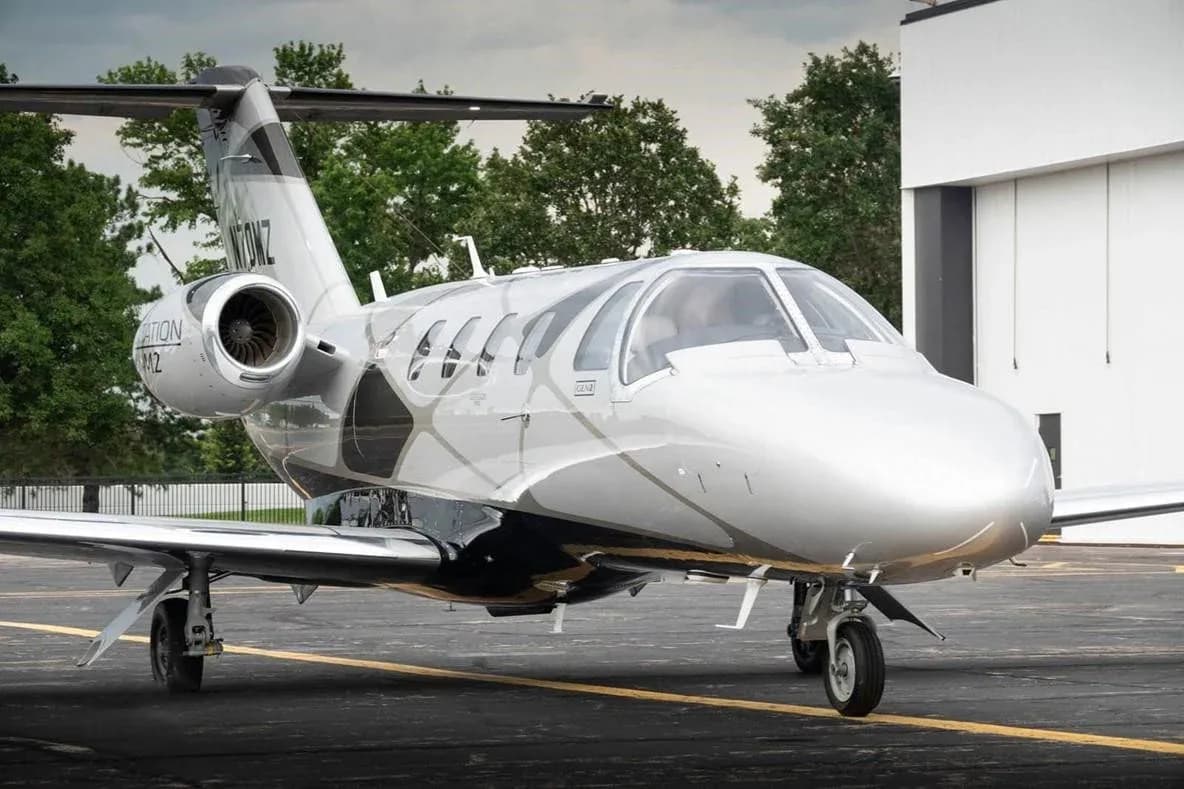 A front-right view of a silver and black Cessna Citation M2 jet (N70MZ) parked on an asphalt ramp.