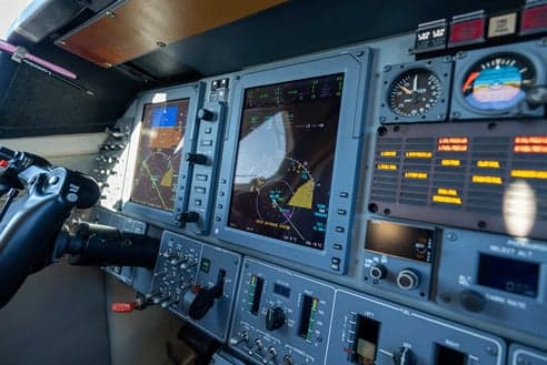 A close-up view of the multi-function displays and instruments in a business jet cockpit.