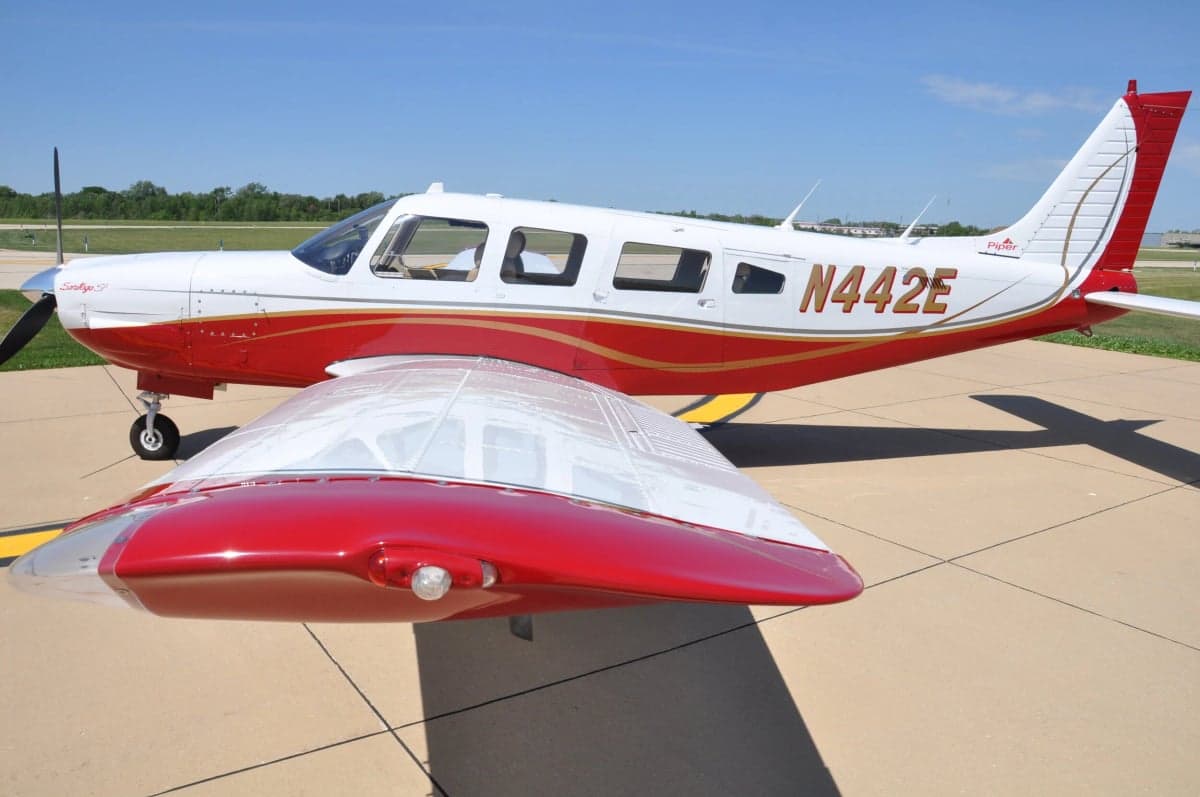 Side view of a Piper Saratoga with red and white paint scheme.