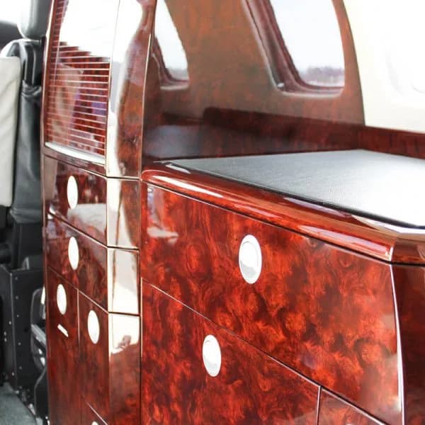 Close-up of the aircraft's highly polished dark wood interior cabinetry with silver accents.