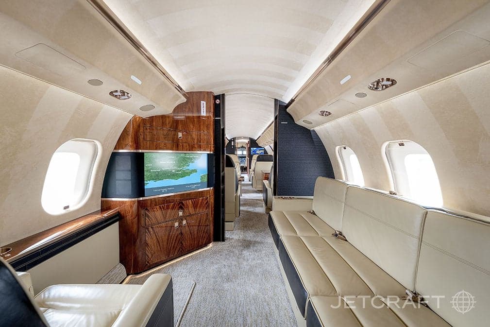 View of the aircraft cabin with a divan and entertainment system.
