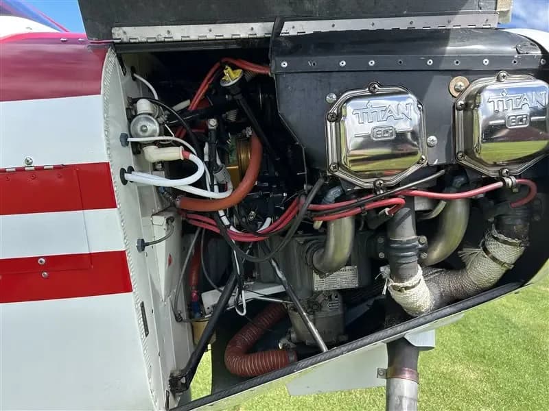 An open view of the aircraft's engine compartment, revealing the Titan engine with its chrome valve covers and various components.