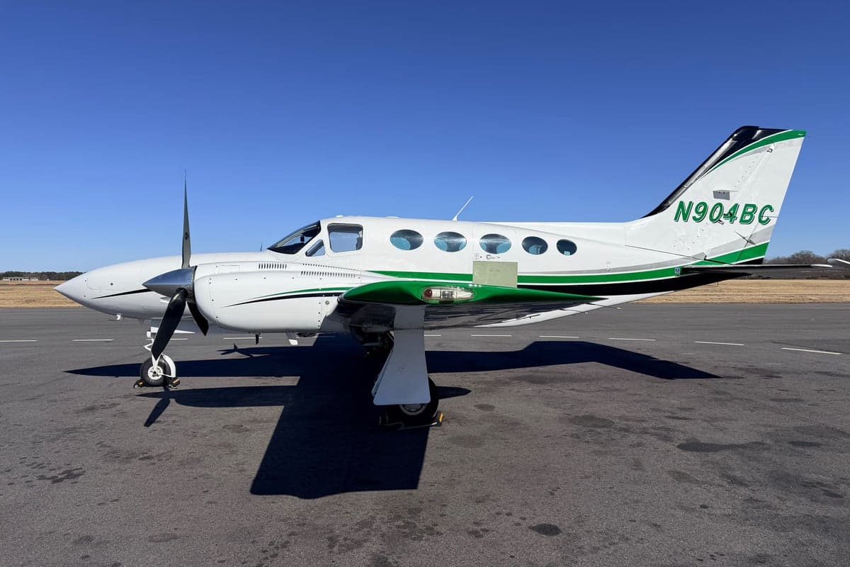 Cessna 414, N904BC, parked on the tarmac with a green and white paint scheme.