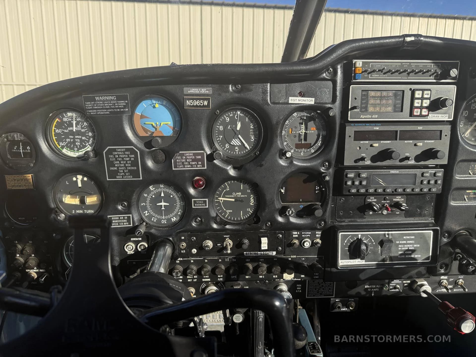 The black instrument panel and controls of a Piper Cherokee 150 aircraft, showing gauges and avionics.