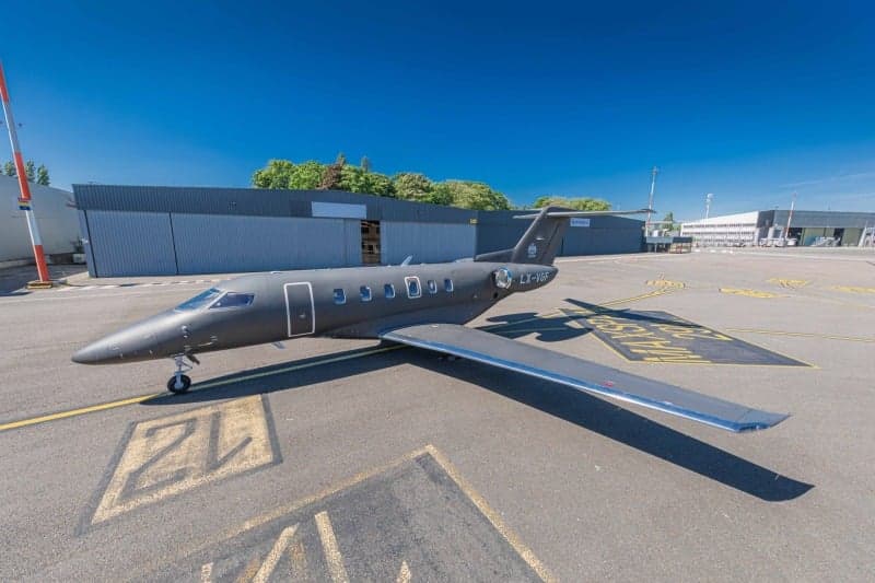 A Bombardier Challenger 350 aircraft with registration LX-VGF has its rear cargo door open.