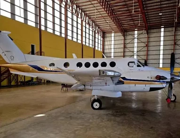 Side view of a King Air aircraft inside a hangar.