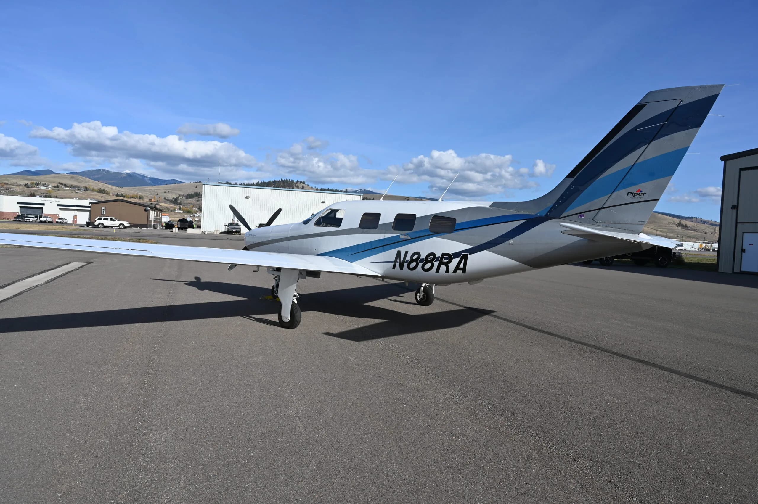Piper Mirage N88RA parked on the tarmac with mountains in the background.