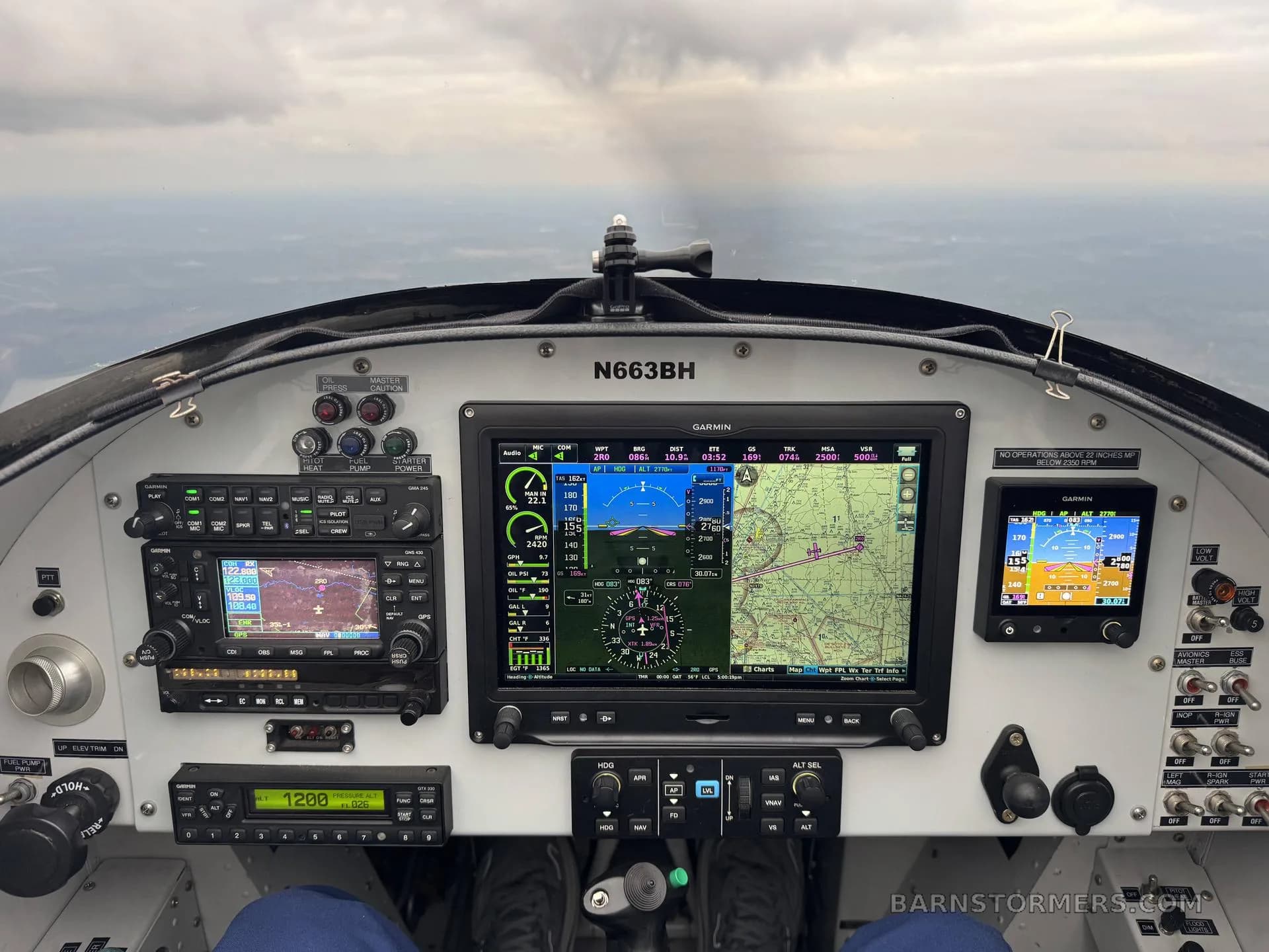 The cockpit of a small aircraft, showing multiple Garmin displays and other instruments, with the registration N663BH visible.