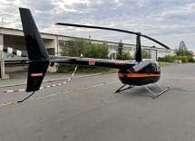 Rear view of a Robinson R44 Raven II helicopter on the tarmac.