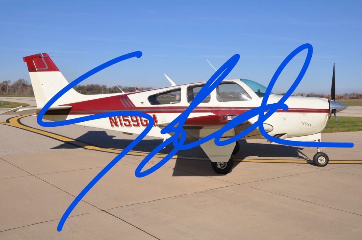 Side view of a Beechcraft Bonanza with a red and white paint scheme, with a blue scribble over the image.