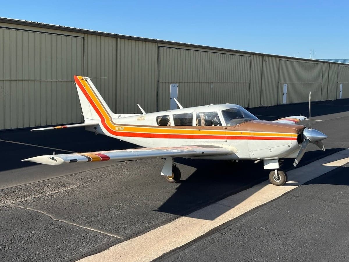Side view of a Piper PA-28-181 Archer II aircraft parked on the tarmac.