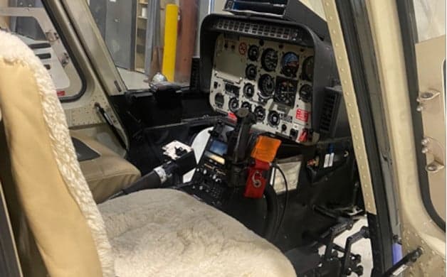 Interior view of the helicopter cabin with tan leather seats.