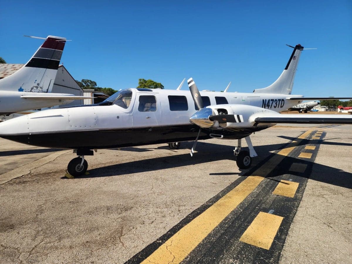 Aircraft N473TD is parked on the tarmac with a white and black paint scheme.