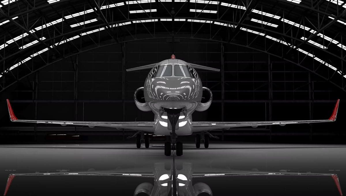 Front view of a gray jet in a hangar with a reflective floor.